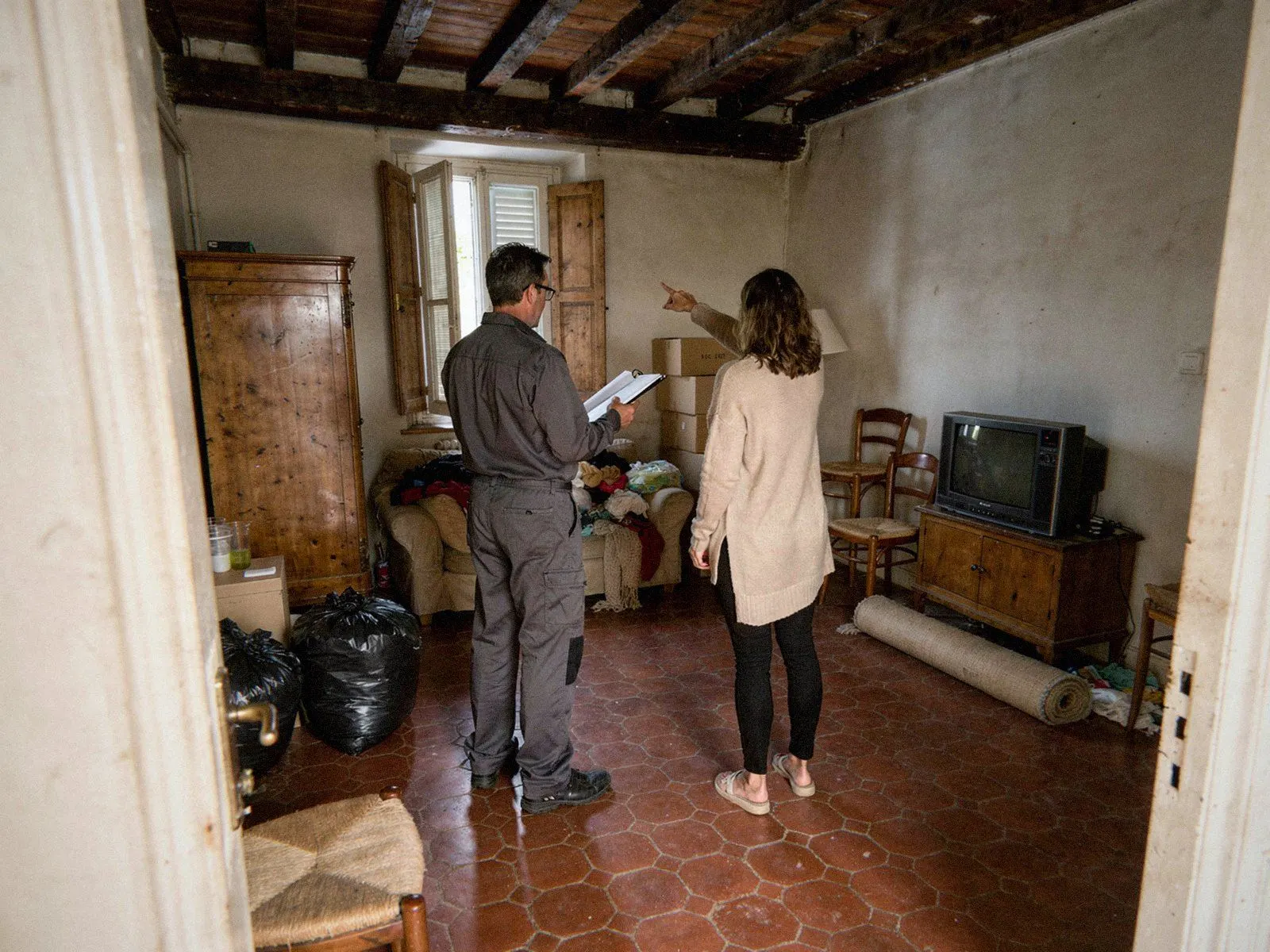 Intervenant carnet en main évaluant les meubles d’un séjour à Lyon, avant de les orienter vers le don