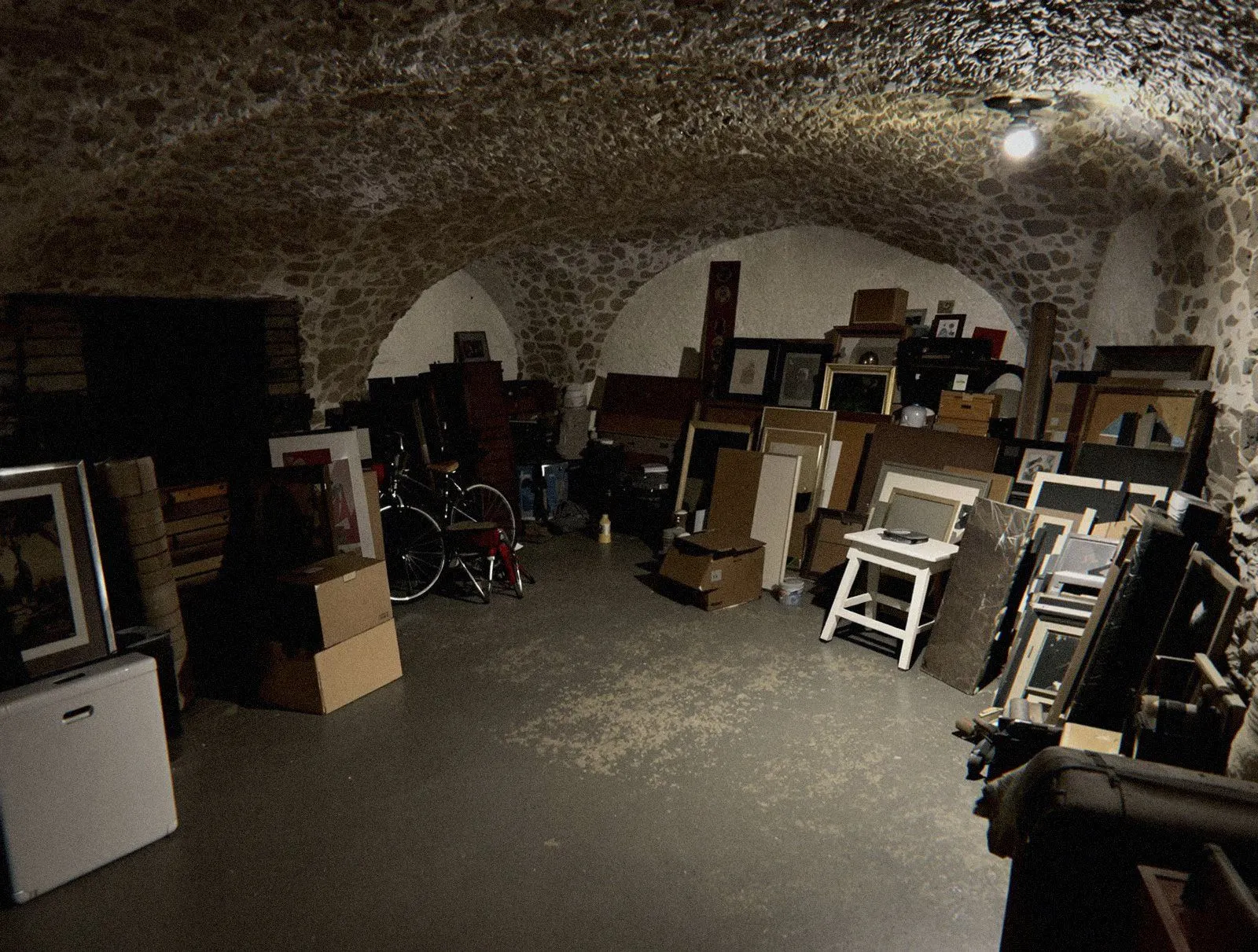 Cave d’immeuble à Lyon remplie de cartons et de vieux meubles, à trier avant un dépôt en donnerie