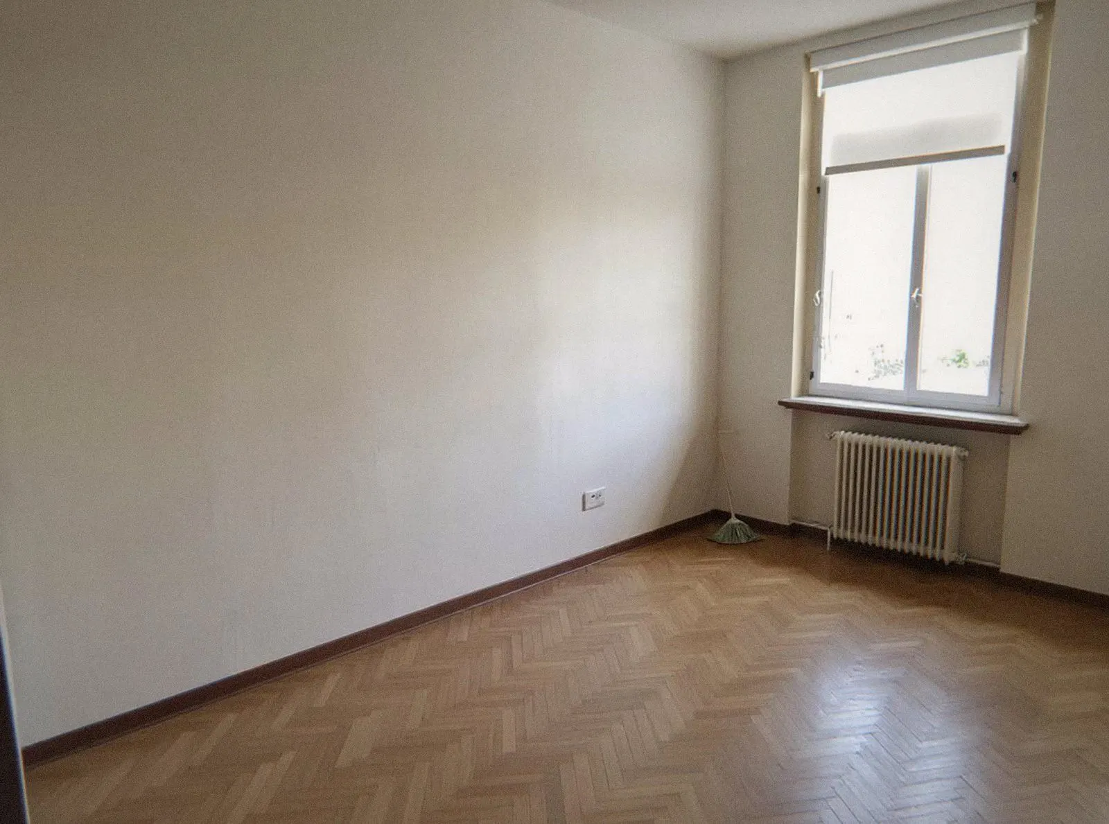 Bureau professionnel vidé, murs sombres et parquet clair dégagés après le débarras des archives
